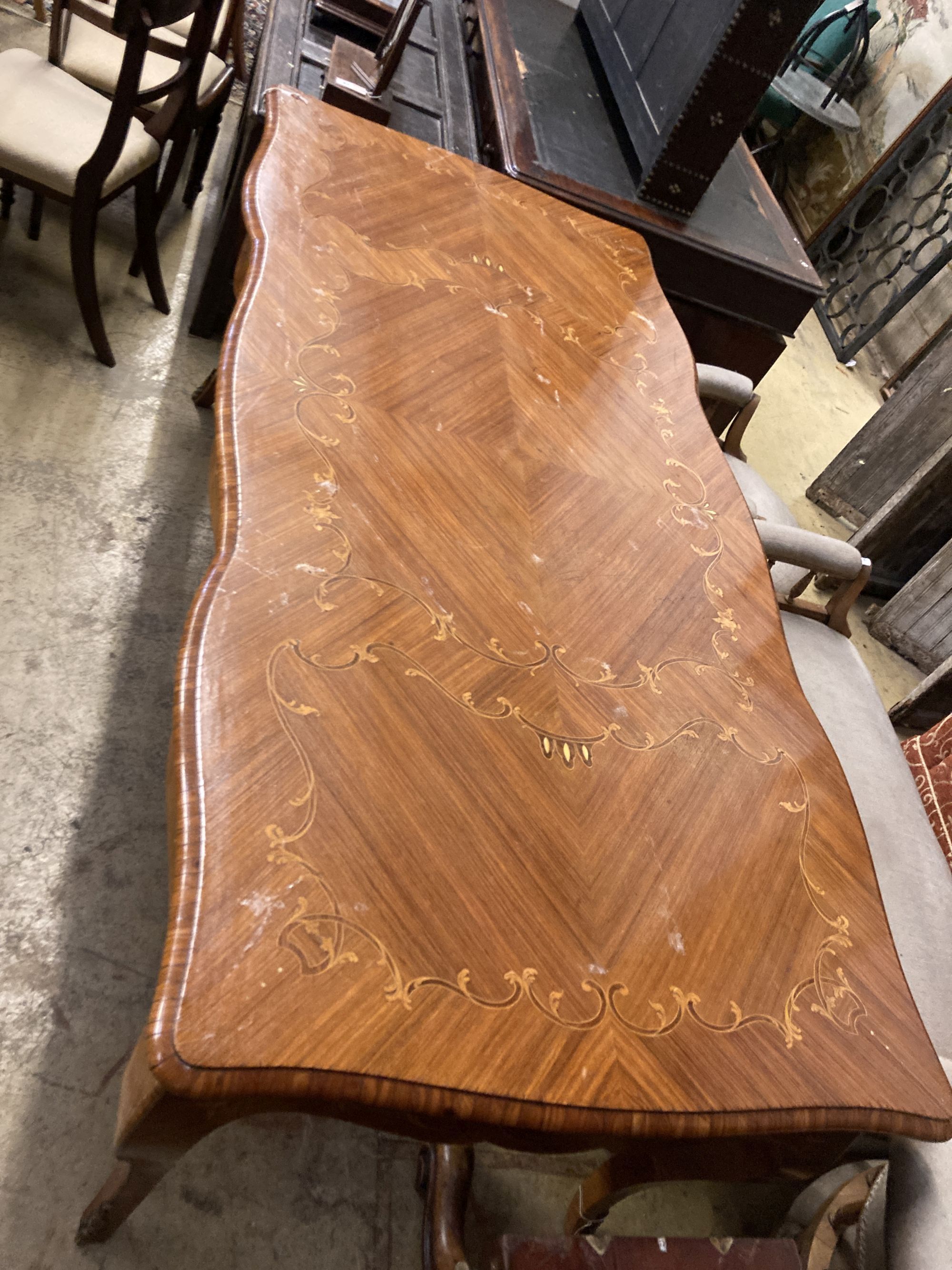 A Louis XVI design marquetry inlaid kingwood serpentine centre table W.196cm. D.90cm. H 79cm.